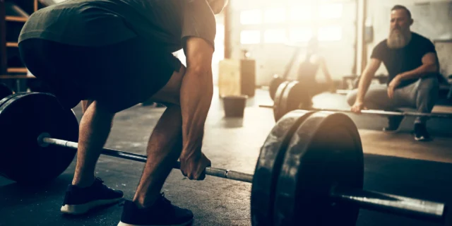 CanvaFitYoungManLiftingHeavyWeightswithaGymPartner